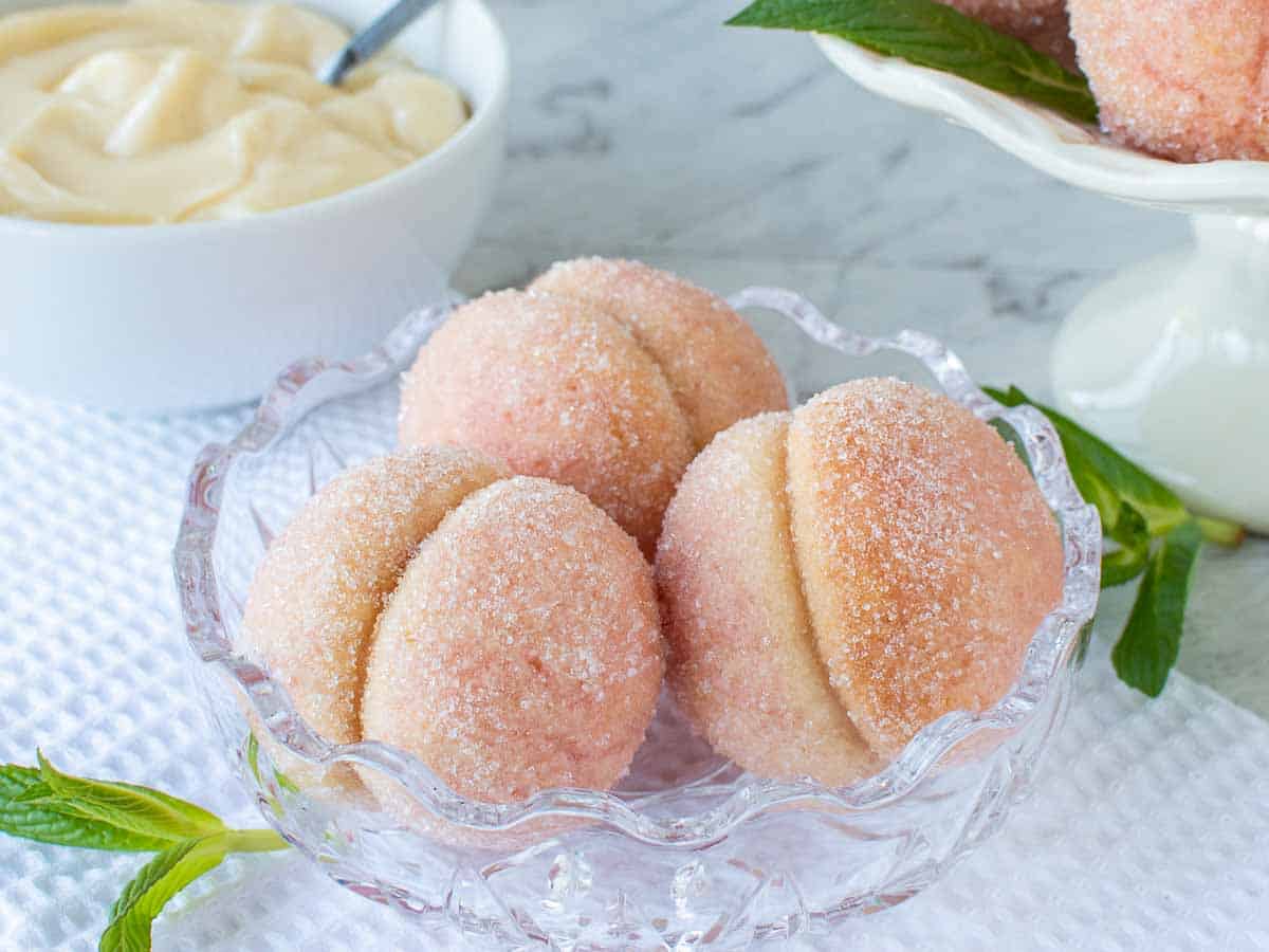 Italian Peach Cookies are two soft cookies sandwiched together with pastry cream then dipped in liqueur to resemble a peach